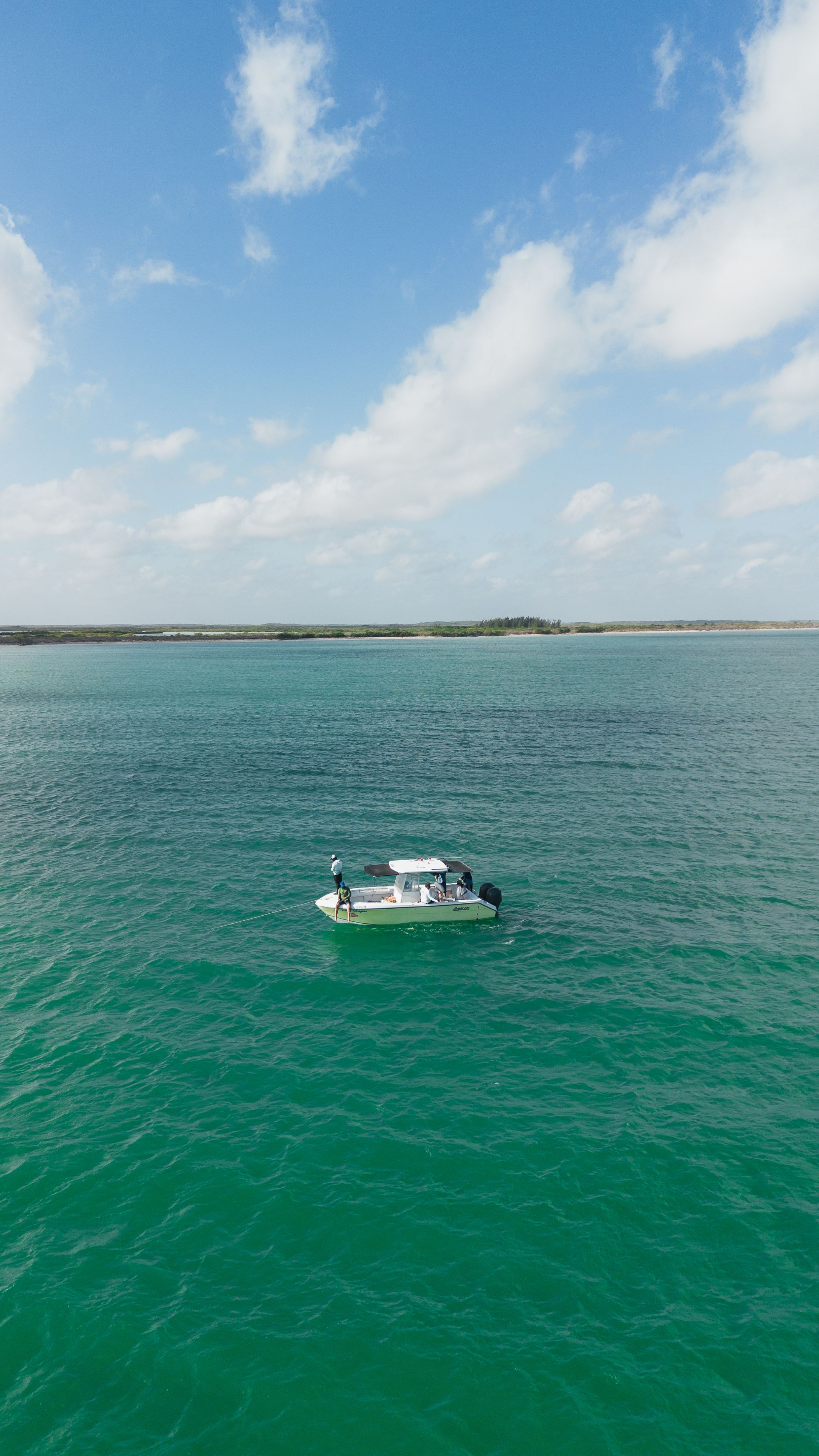 A small boat viewed from above in clear turquoise sea