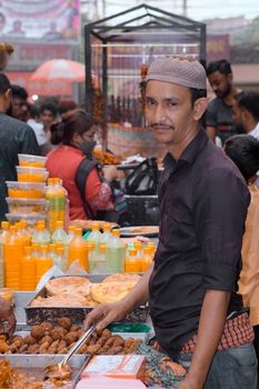 A street vendor selling fresh juices and snacks at a bustling outdoor market.