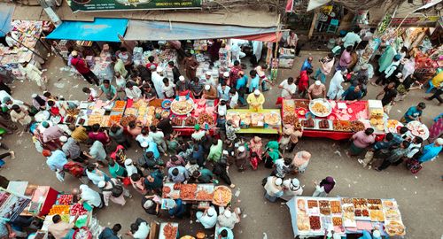 Free Busy street market with diverse food stalls and crowds from an overhead view. Stock Photo
