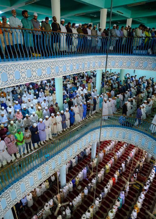 Free A crowded mosque with multiple levels filled with people attending a prayer service, showcasing unity and devotion. Stock Photo