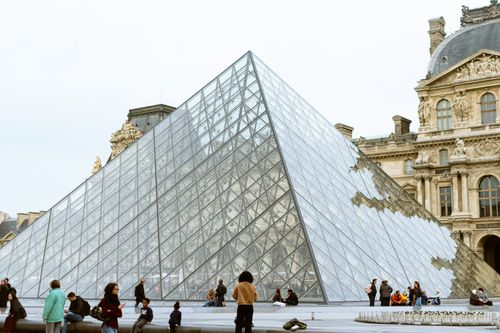 Free Captivating view of the glass Louvre Pyramid surrounded by visitors in Paris, France. Stock Photo