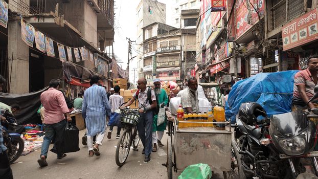 Lively street scene in Dhaka, showcasing vendors, shoppers, and local architecture.
