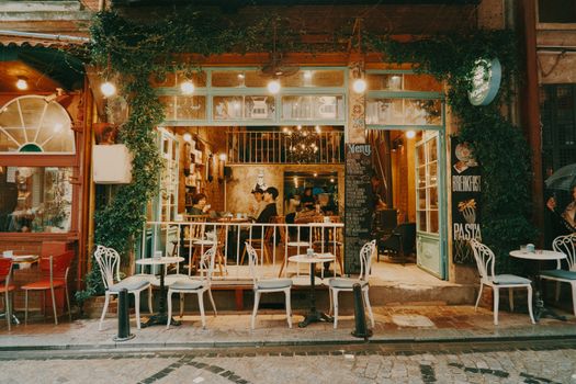 Cozy outdoor cafe setting with tables and chairs, inviting ambiance for socializing and dining.