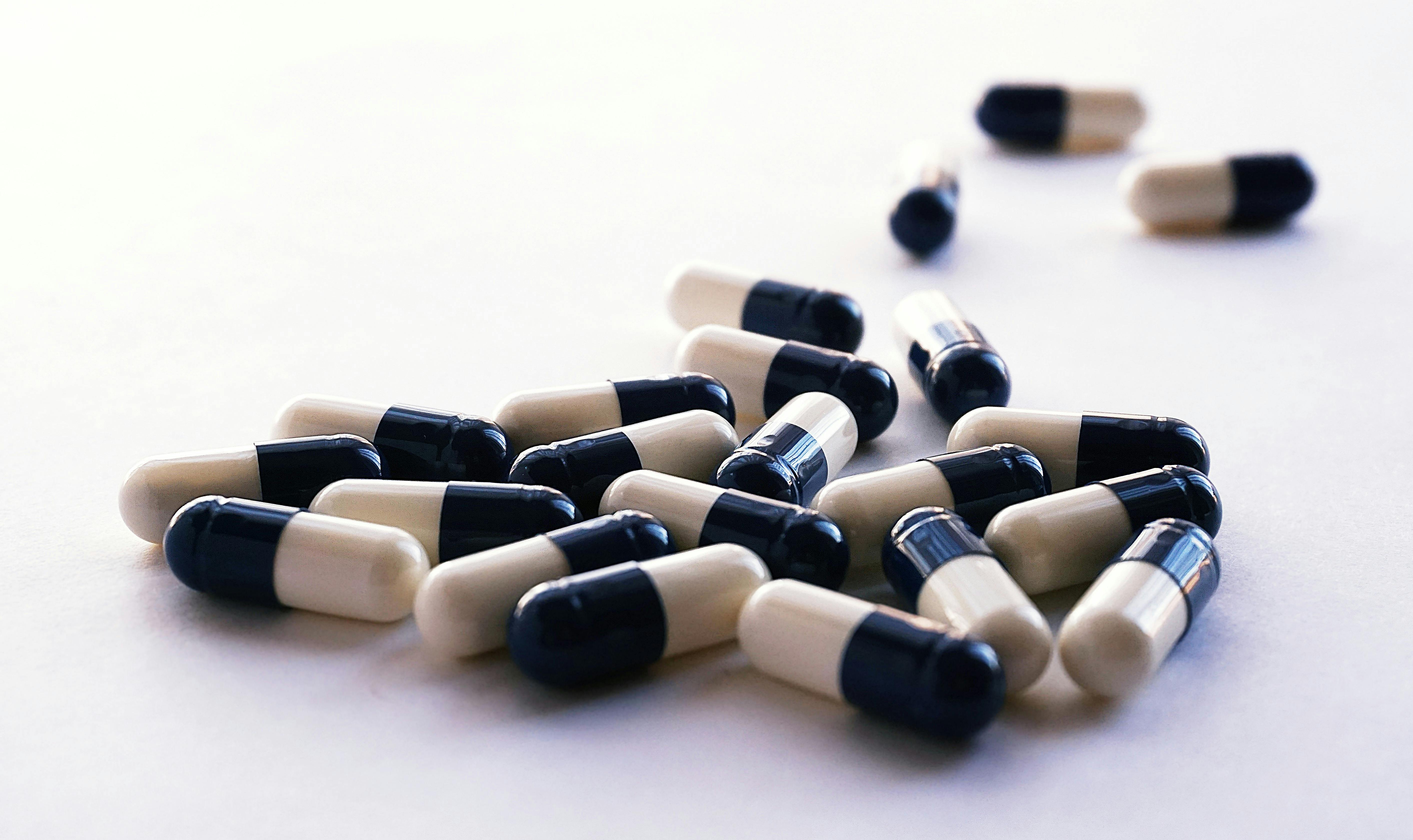 White And Black Medicine Capsules Free Stock Photo