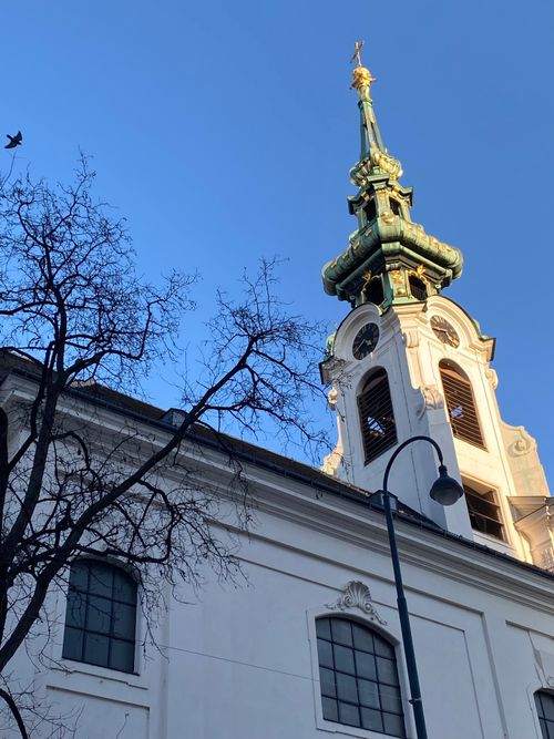 Free A picturesque view of a Baroque church spire in Vienna, Austria, captured at sunset. Stock Photo