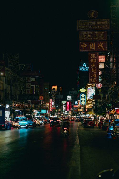 Free Lively street scene at night with vibrant neon signs illuminating a bustling cityscape. Stock Photo