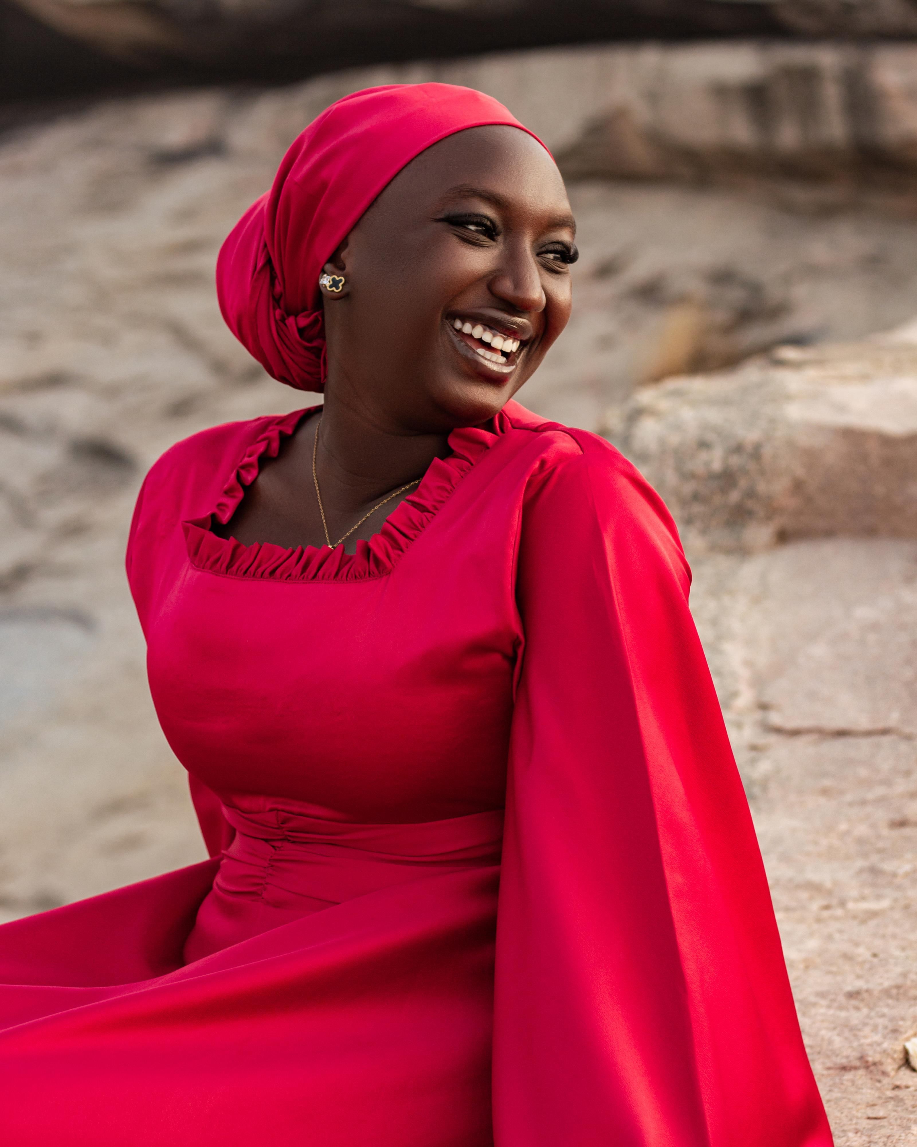 Smiling Woman in Red Dress Outdoors · Free Stock Photo