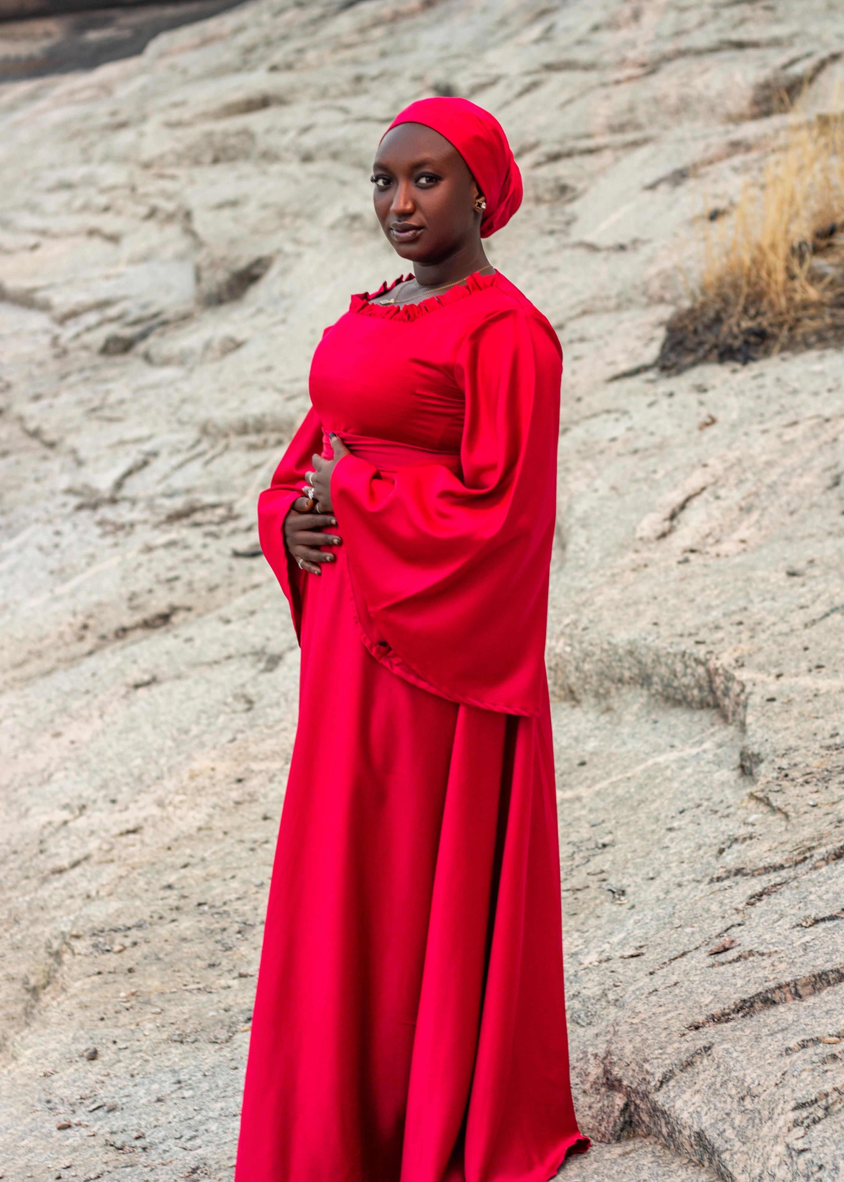 Elegant Woman in Red Dress on Rocky Terrain · Free Stock Photo
