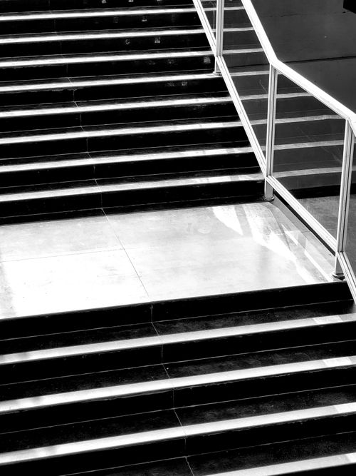 Free Black and white photo of a sleek indoor staircase with glass railings in Ghaziabad, India. Stock Photo