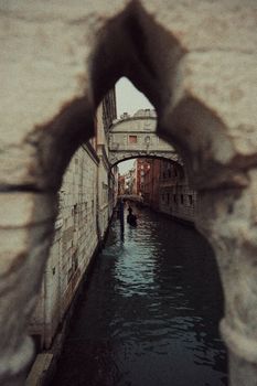 Captivating view of a gondola through an archway in Venice, showcasing the city's historic charm.