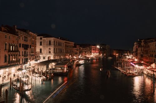 Free Stunning nighttime view of Venice's Grand Canal with vibrant city lights reflecting on the water. Stock Photo