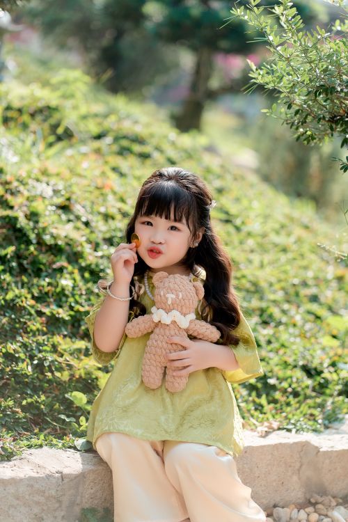 Free Cute little girl enjoying outdoors with her teddy bear during a sunny spring day. Stock Photo