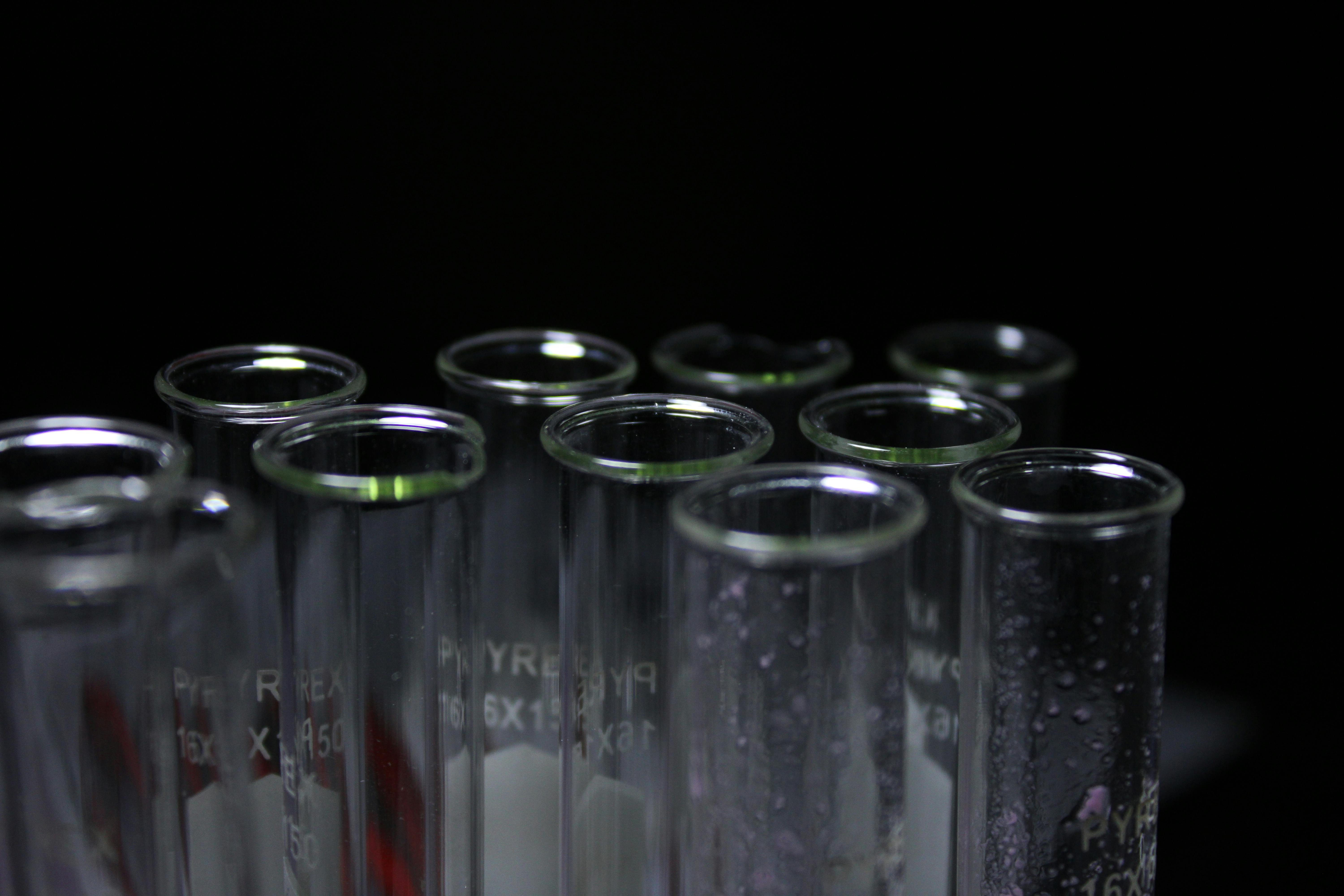 ฟรี หลอดทดลองแก้วที่มีหยดน้ำเกาะอยู่ภายใน ในห้องปฏิบัติการที่มีแสงสลัว คลังภาพถ่าย