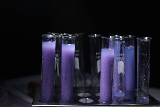 Close-up of purple liquid in test tubes against a black background, ideal for scientific and educational content.