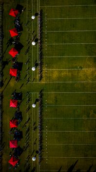 Aerial photograph showing a sports field with players and red umbrellas, Antalya, Türkiye.