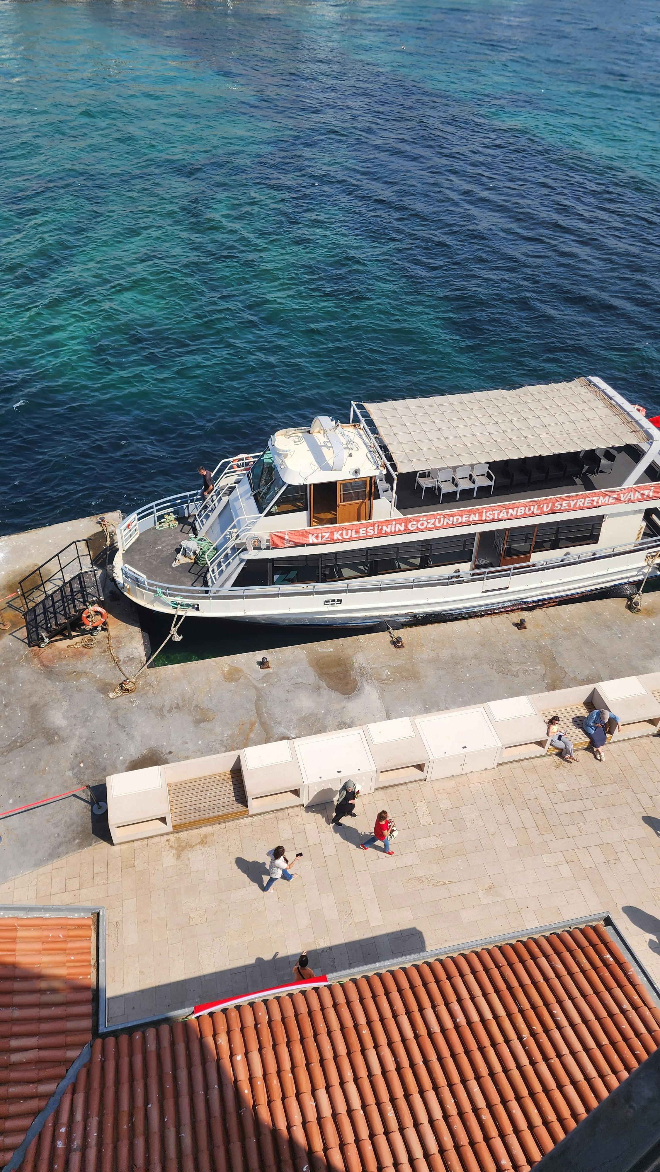 Miễn phí Chiếc phà cập bến tại khu vực bờ sông Istanbul thơ mộng vào một ngày hè nắng đẹp, xung quanh có nhiều người đi dạo. Ảnh lưu trữ