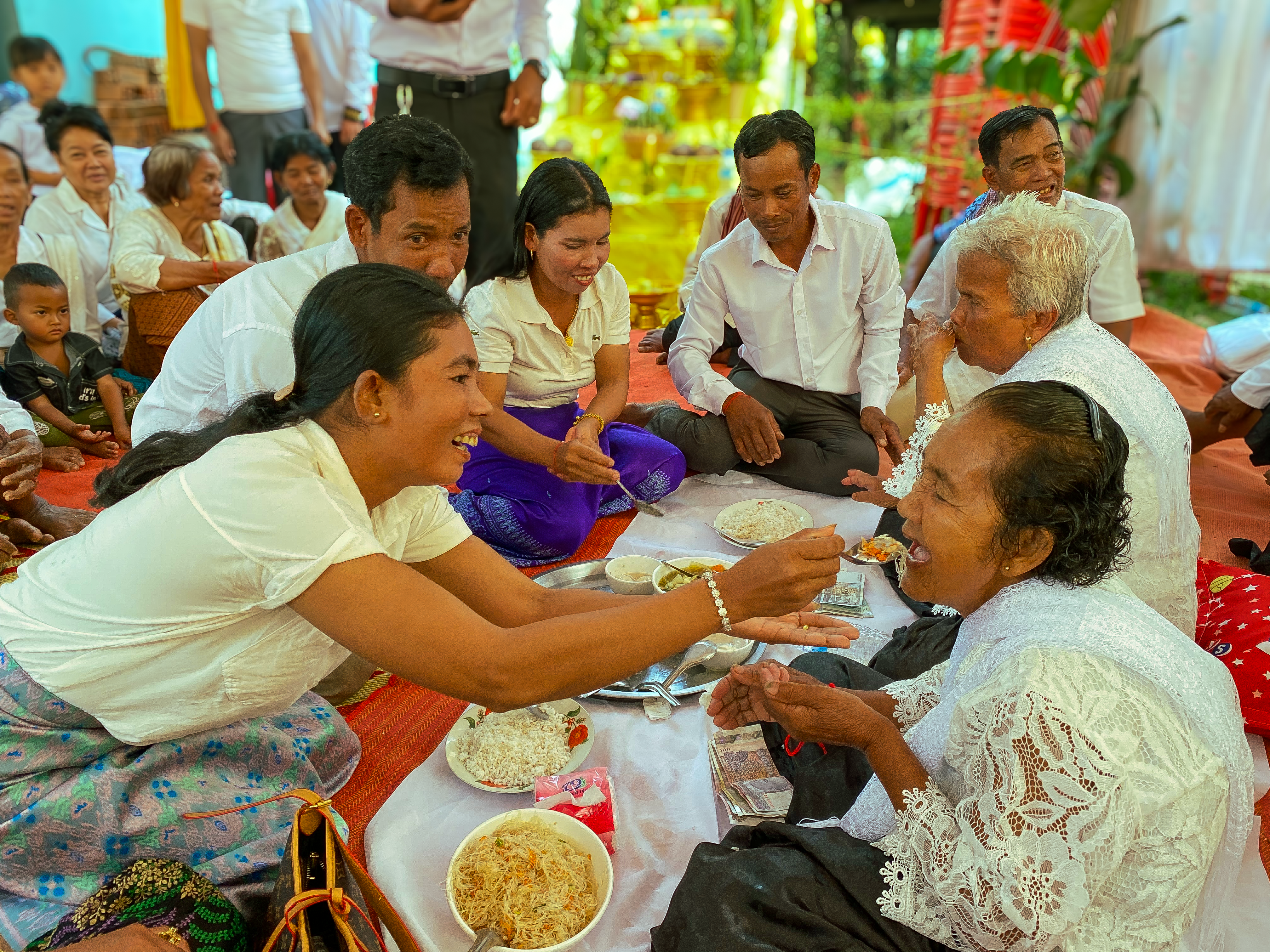 tourists and locals sharing a meal in a home setting, cultural exchange