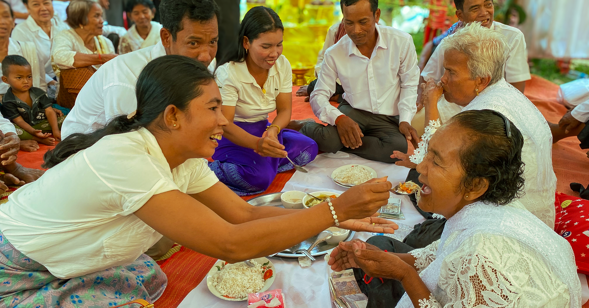 tourists and locals sharing a meal in a home setting, cultural exchange