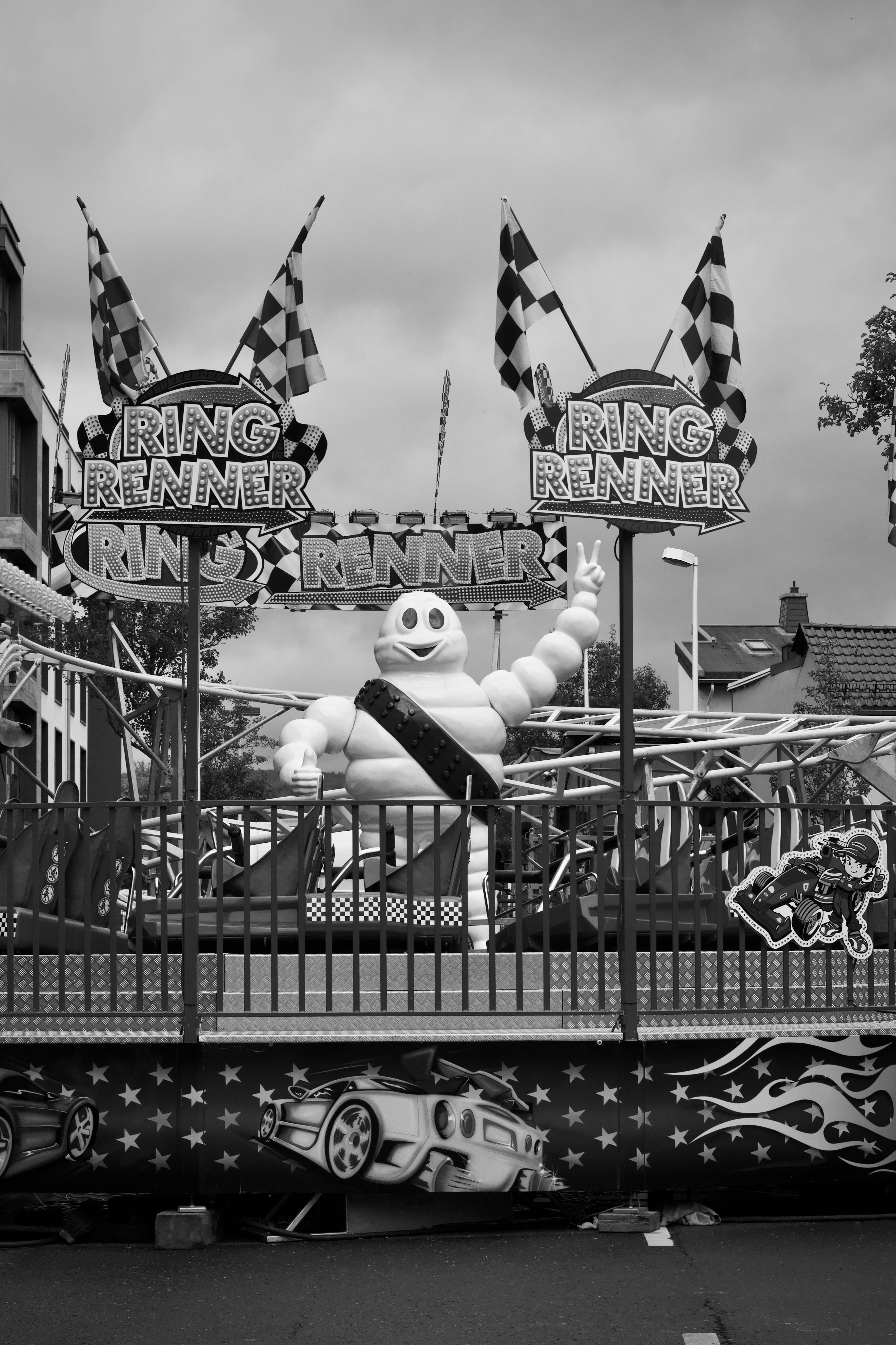 Free A monochrome image of a fairground ride featuring an inflatable figure and decorative elements. Stock Photo