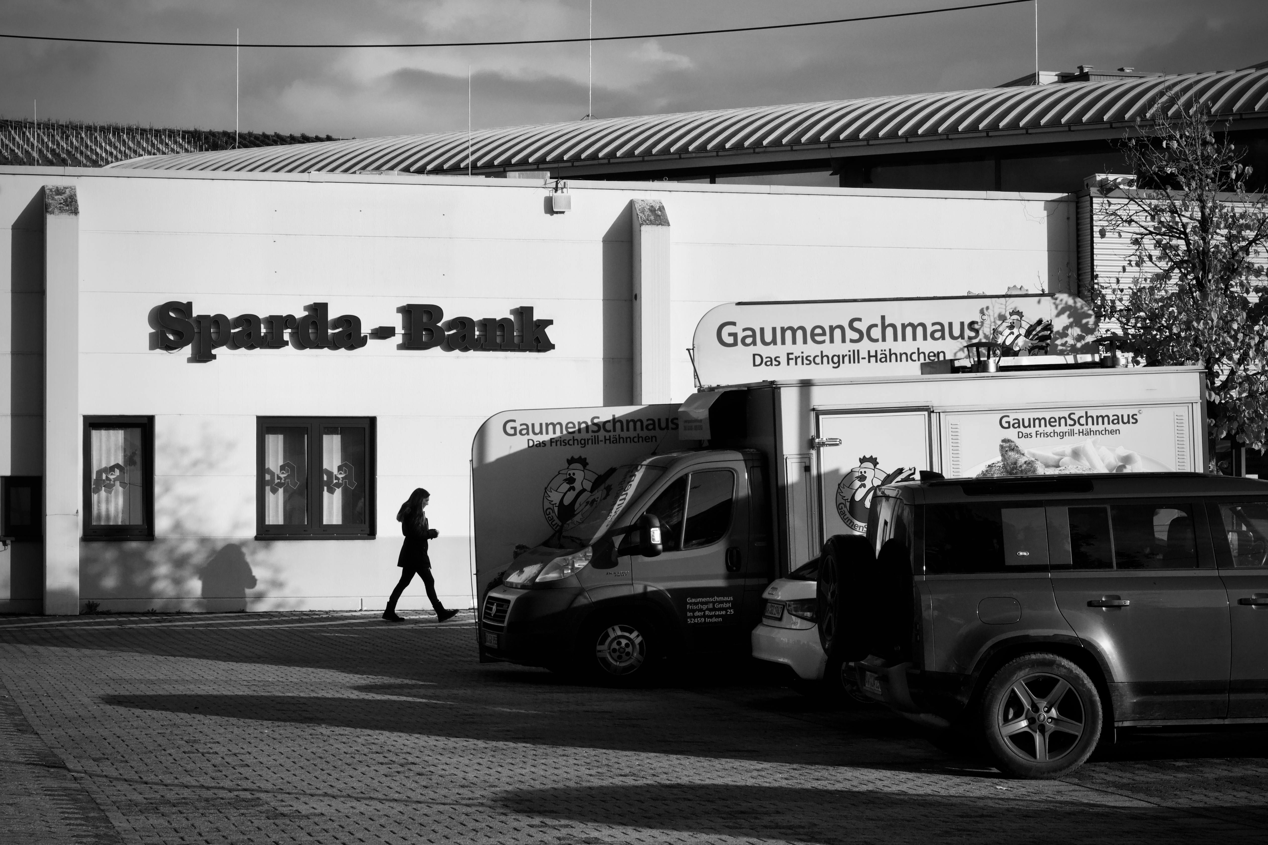 Ücretsiz Sparda-Bank binasının, araçların ve bir yayaın yer aldığı siyah beyaz fotoğraf. Stok Fotoğraflar