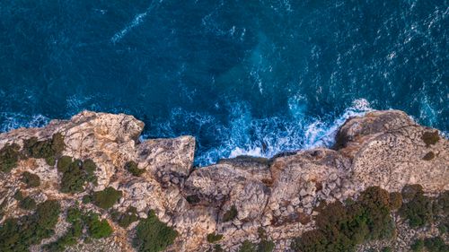 Free Stunning aerial shot of rocky cliffs and vibrant blue sea in Islas Baleares, Spain. Stock Photo