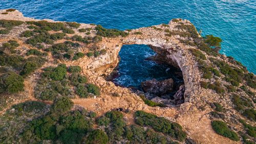 Free Stunning aerial shot of a natural rocky arch along the coast of Mallorca, Spain. Stock Photo