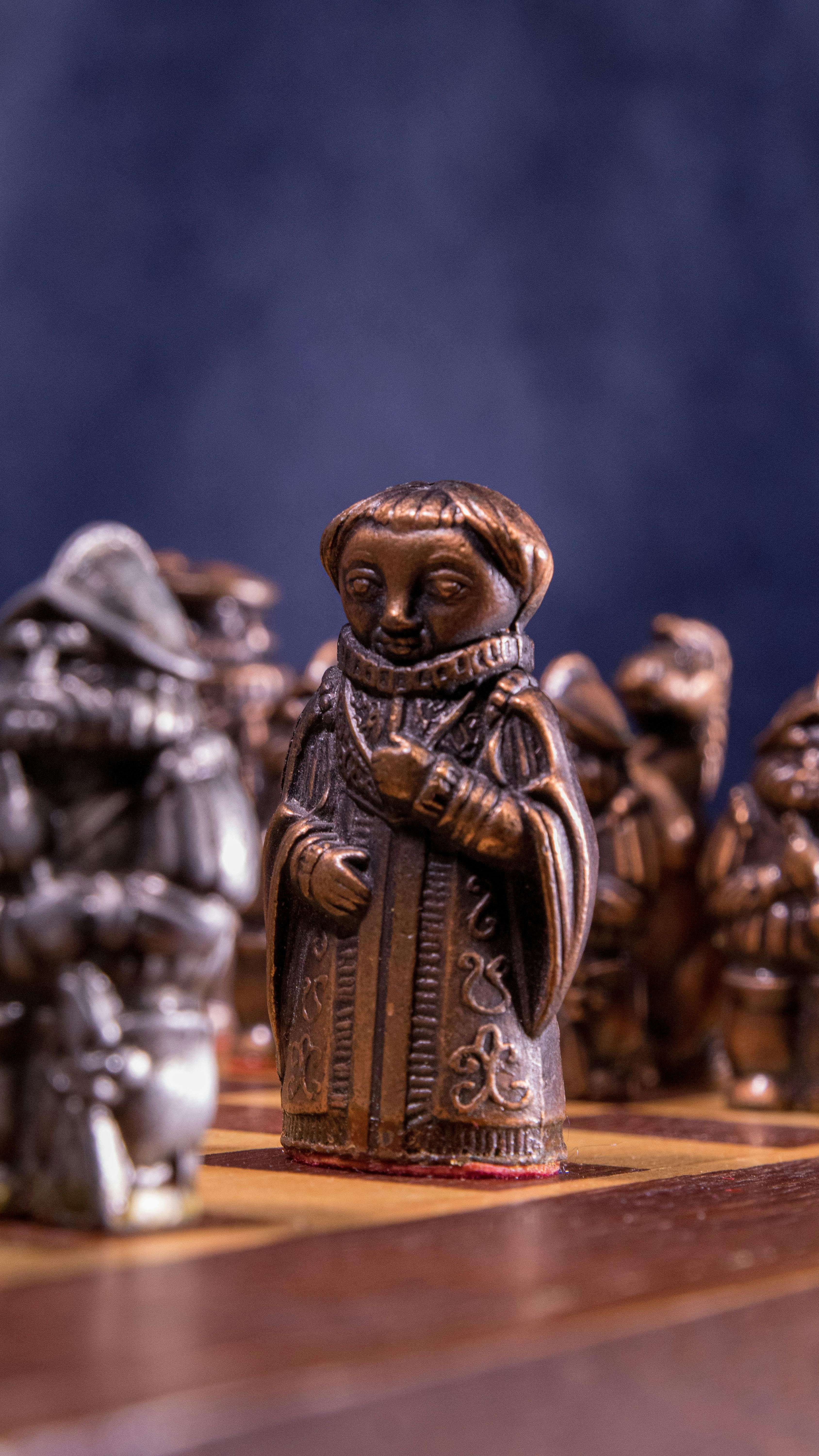 Free Close-up of ornate medieval chess pieces in artistic display on a wooden board. Stock Photo