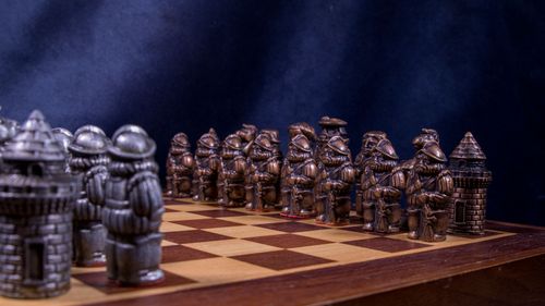 Free Intricately detailed medieval-themed chess set with metal pieces on a wooden board. Stock Photo