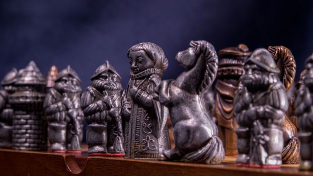 Close-up of metallic medieval chess pieces on a board, capturing the craftsmanship and detail.
