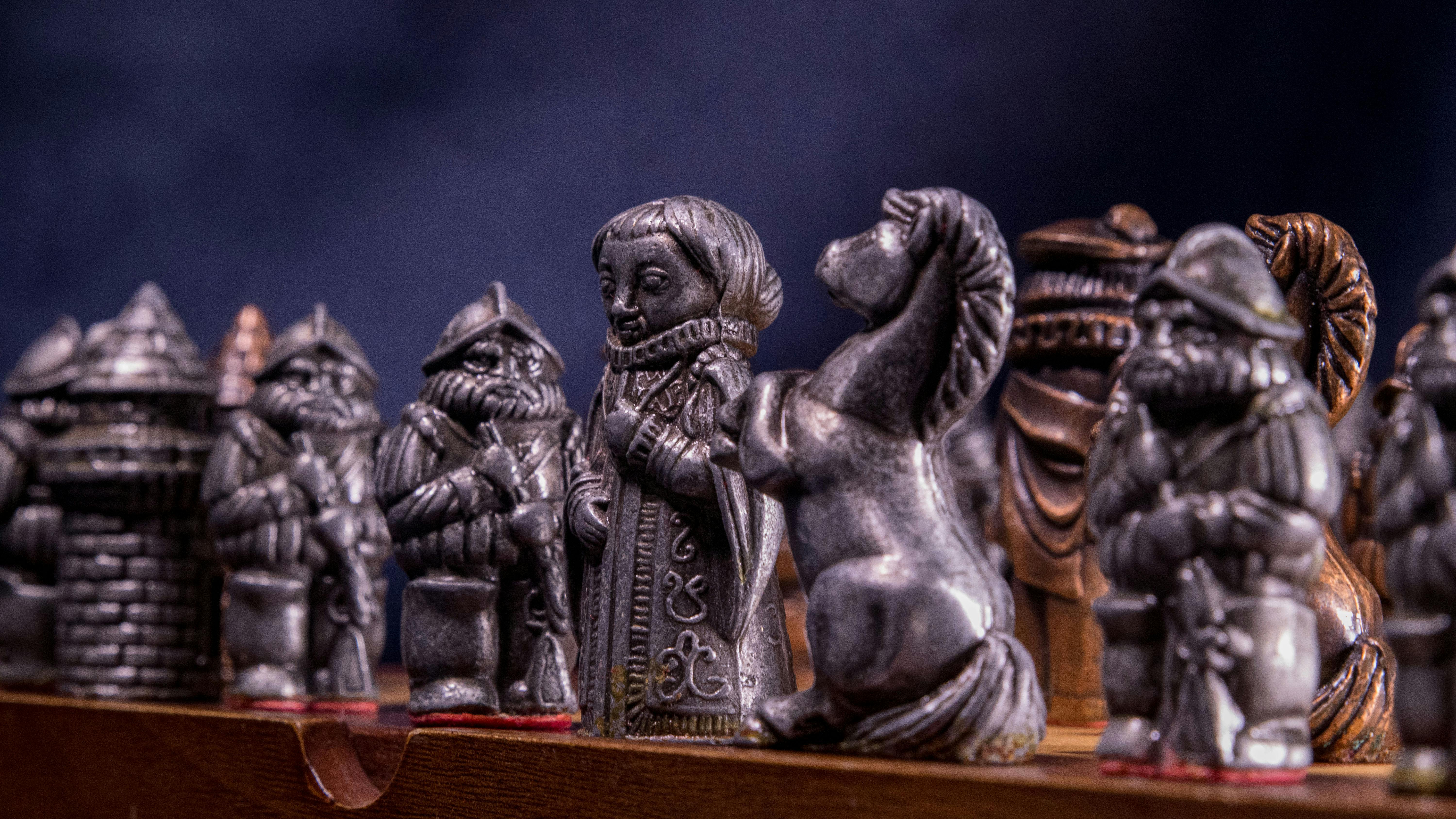 Free Close-up of metallic medieval chess pieces on a board, capturing the craftsmanship and detail. Stock Photo