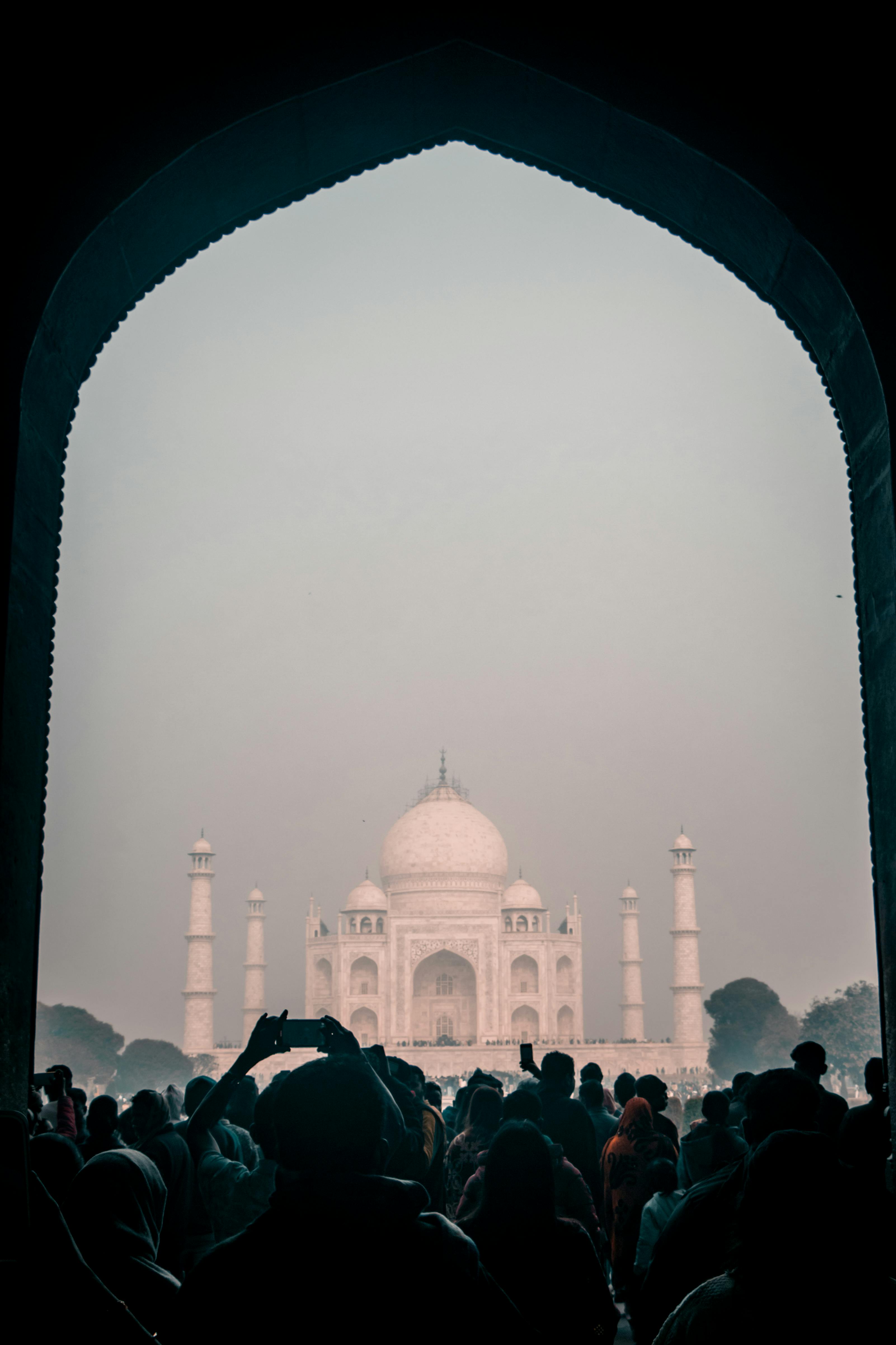 Gratis Sagome di turisti sotto un arco che ammirano l'iconico Taj Mahal all'alba ad Agra, in India. Foto a disposizione