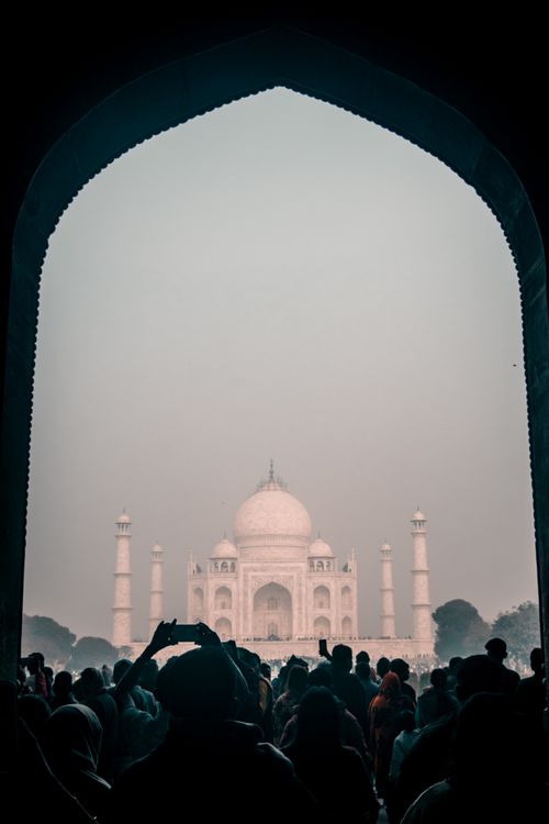 Free Silhouette of tourists under an archway viewing the iconic Taj Mahal at dawn in Agra, India. Stock Photo