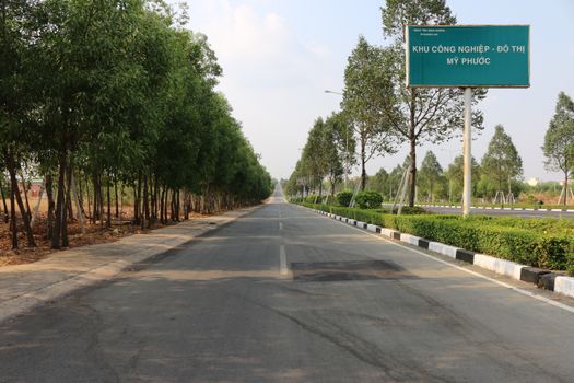 Scenic view of a tree-lined road in My Phuoc Industrial Park on a sunny day.