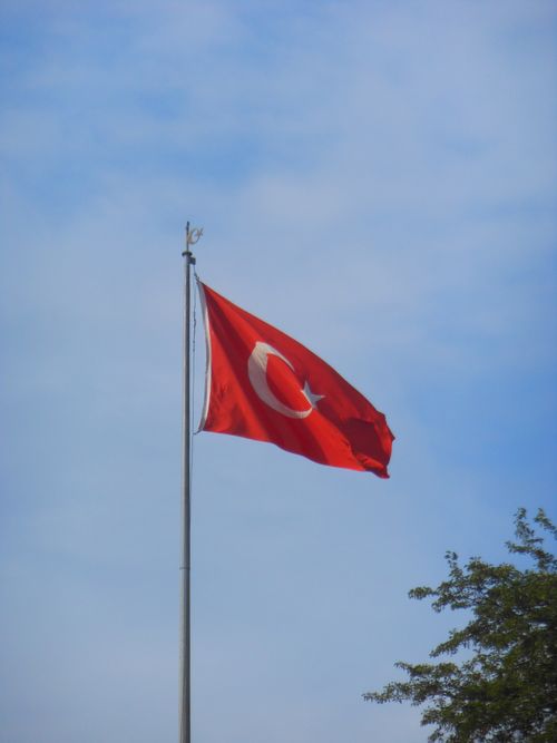 Free Turkish flag waving high on a flagpole with a clear blue sky backdrop, symbolizing national pride. Stock Photo