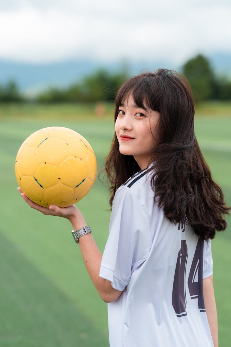 Woman Wearing White Shirt Holding Yellow Soccer Ball