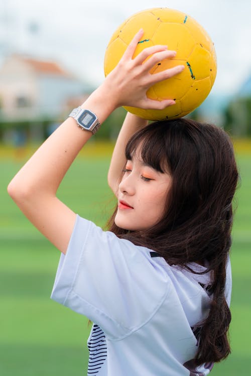 Femme Tenant Un Ballon De Football Jaune