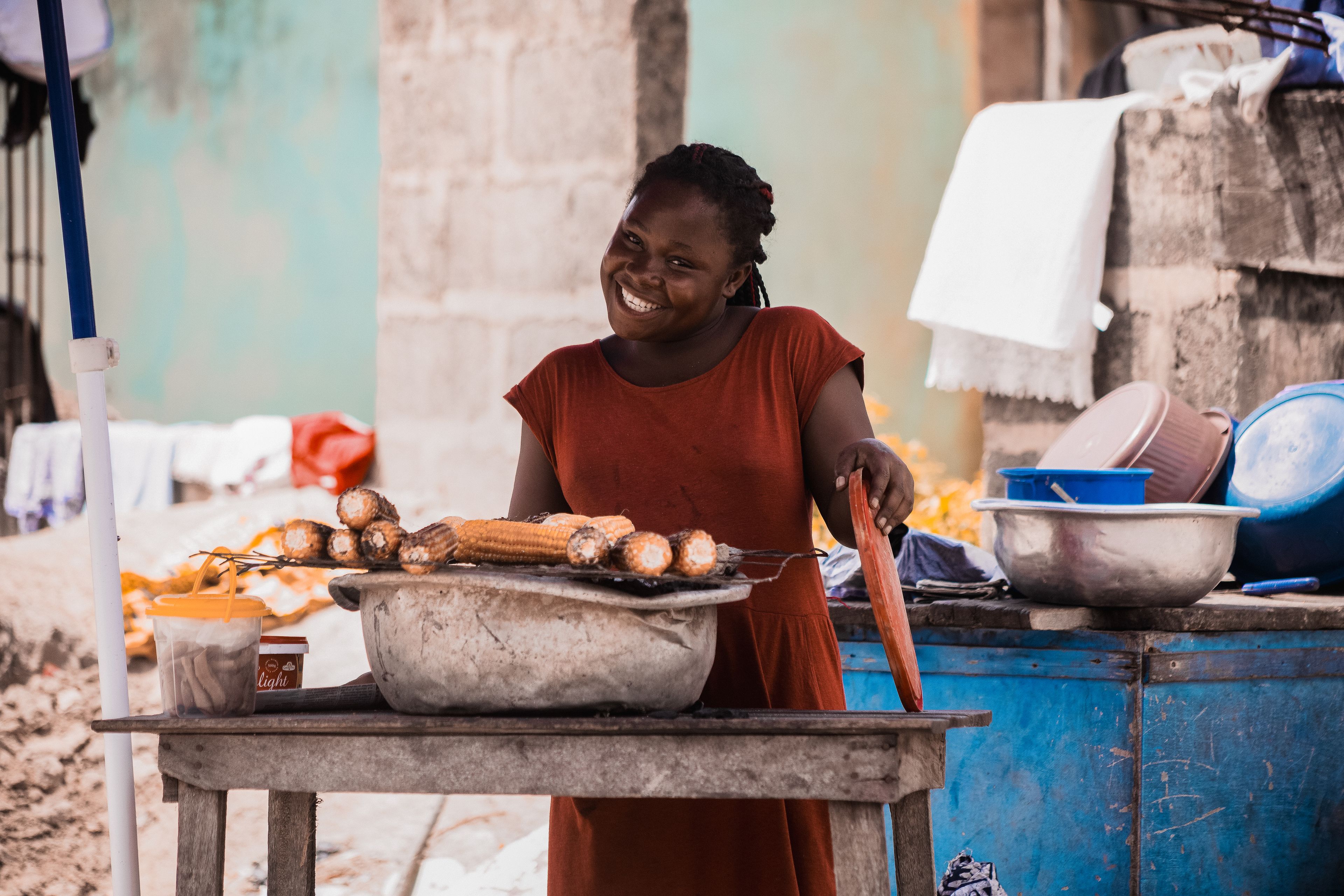 A vendor smiling as she sells roasted corn in Takoradi
