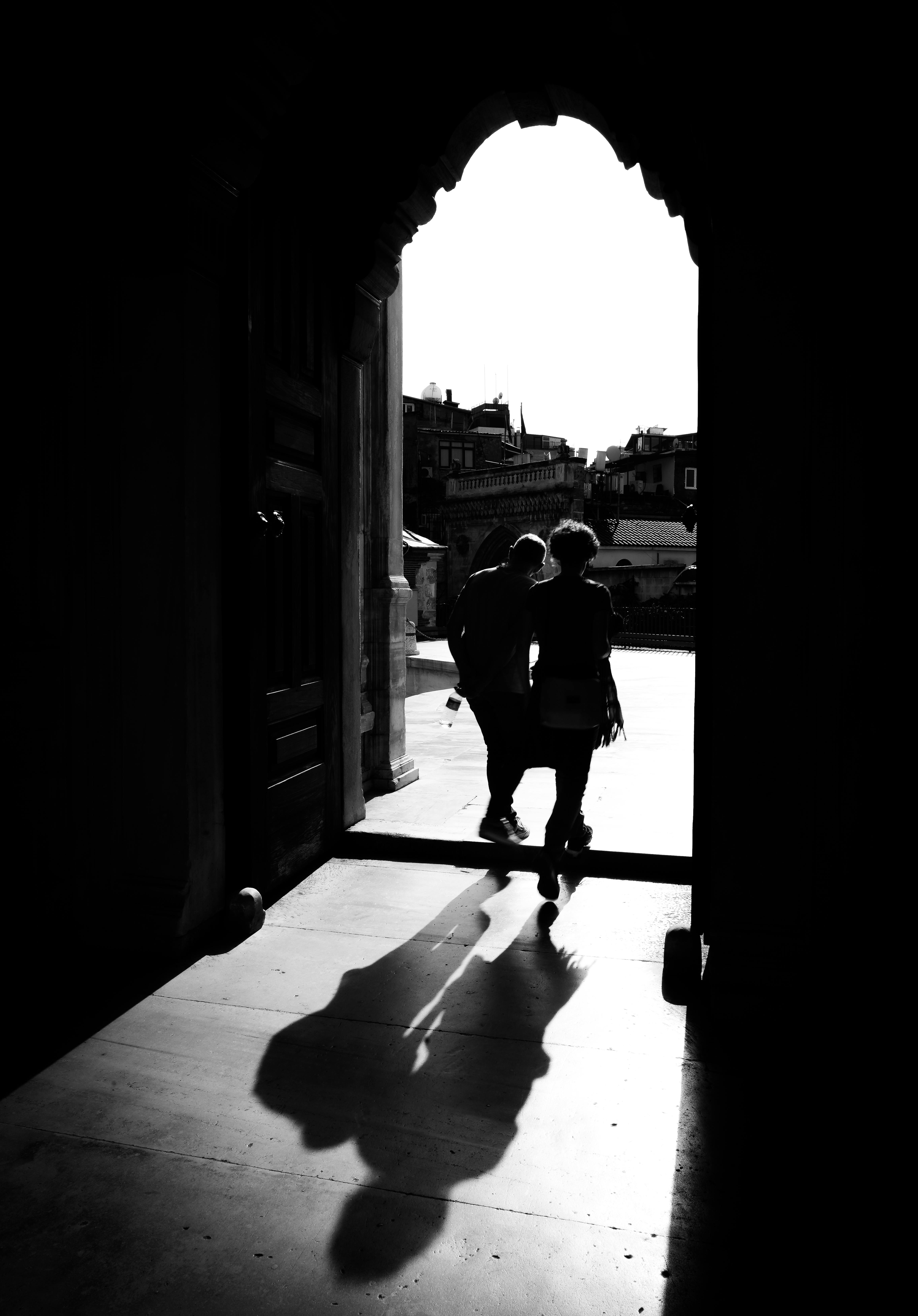 Gratuit Photo en noir et blanc capturant des silhouettes et des ombres dans une arche. Photos
