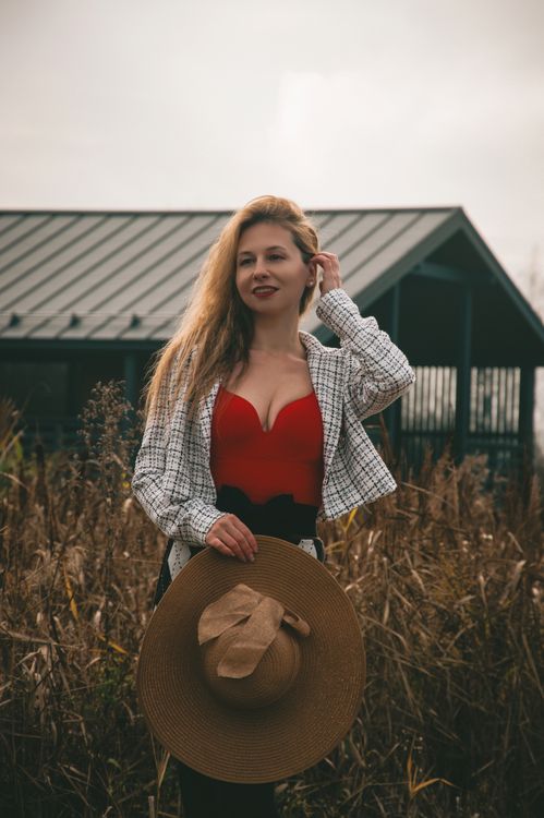 Stylish Woman Posing Outdoors with Hat · Free Stock Photo