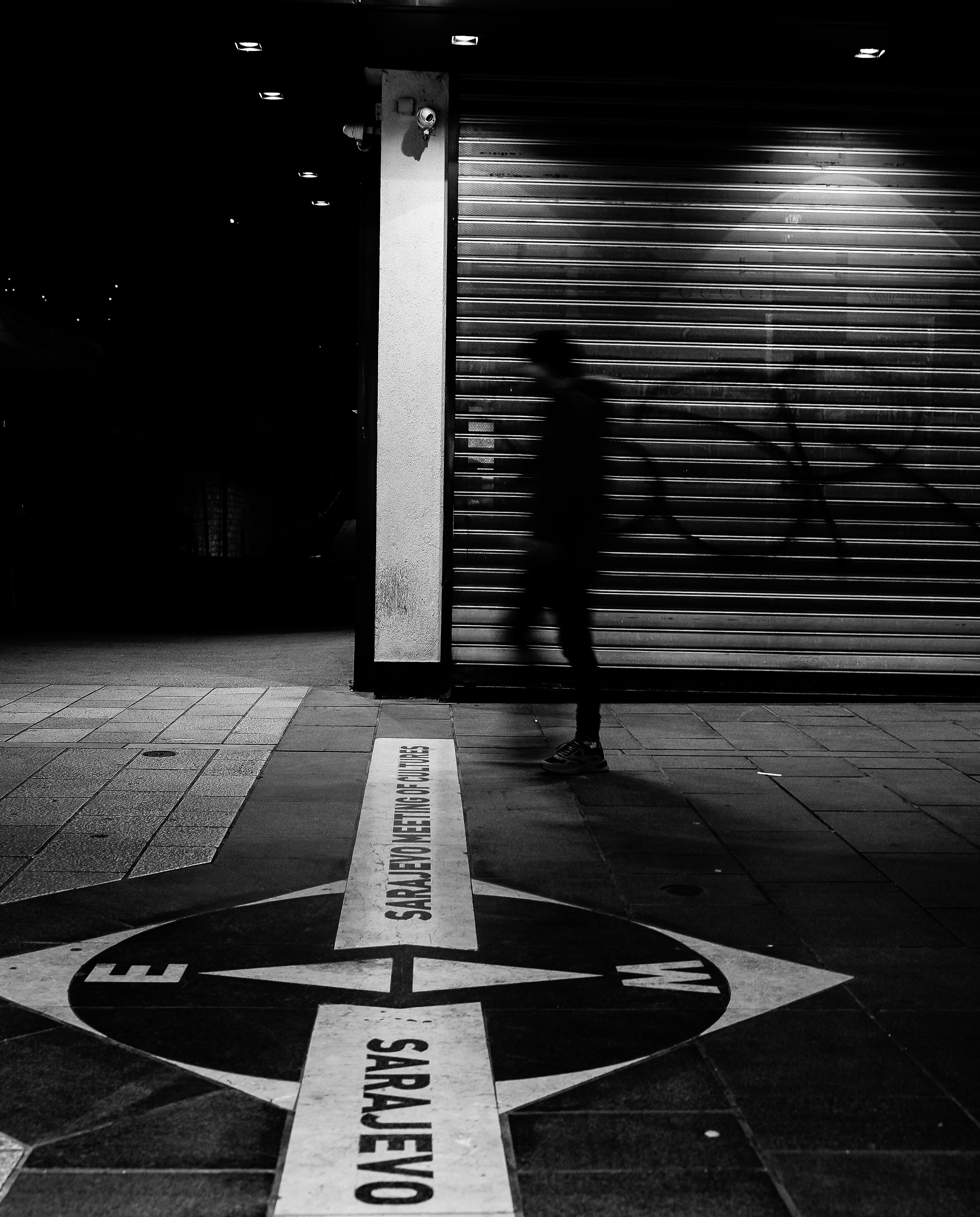 無料 サラエボの街並みを捉えた、陰影のある人物とコンパスの目盛りが写った、雰囲気のあるモノクロ写真。 写真素材