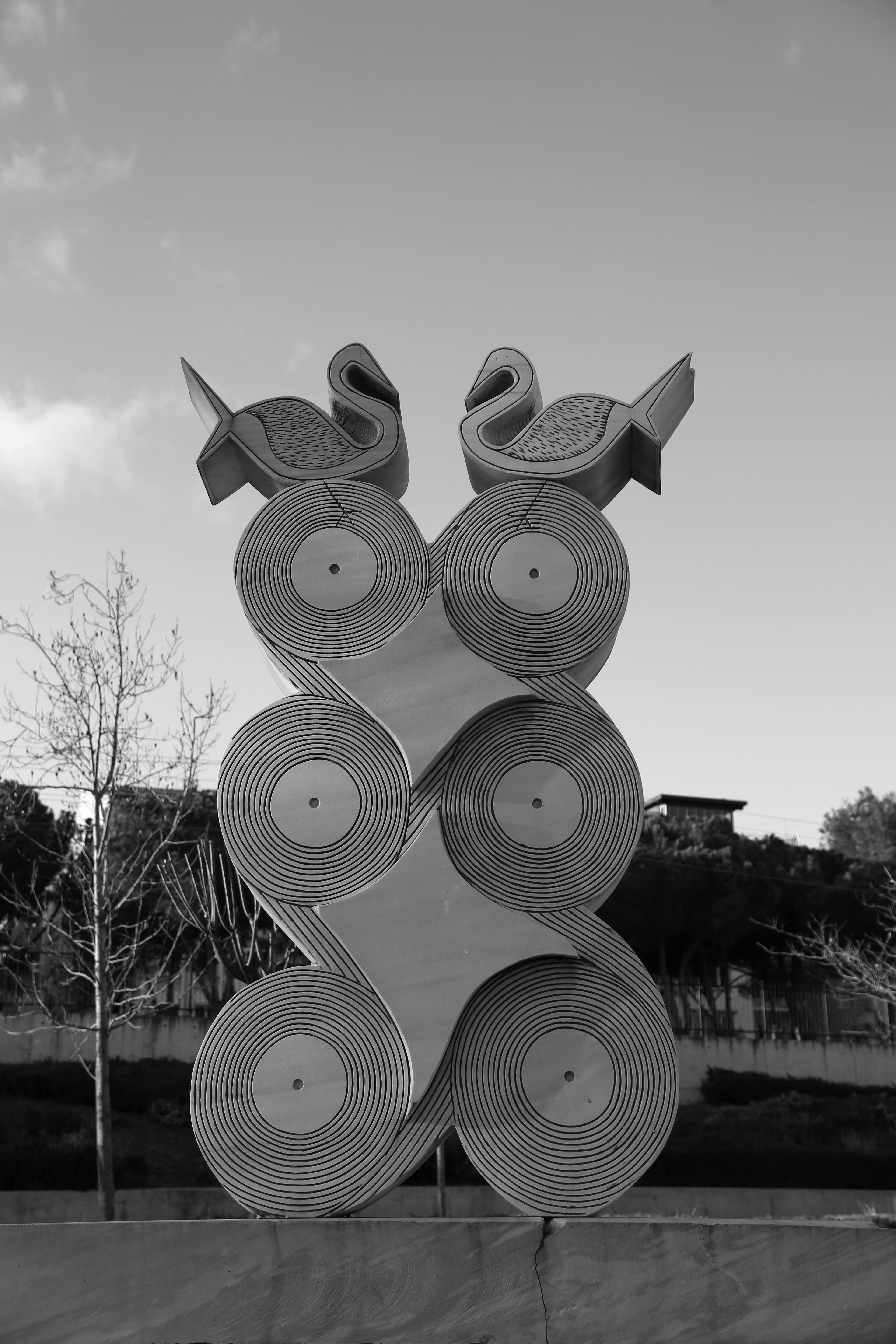 Gratis En moderne metallskulptur med geometriske former og fugler utendørs i en monokrom setting. Arkivbilde