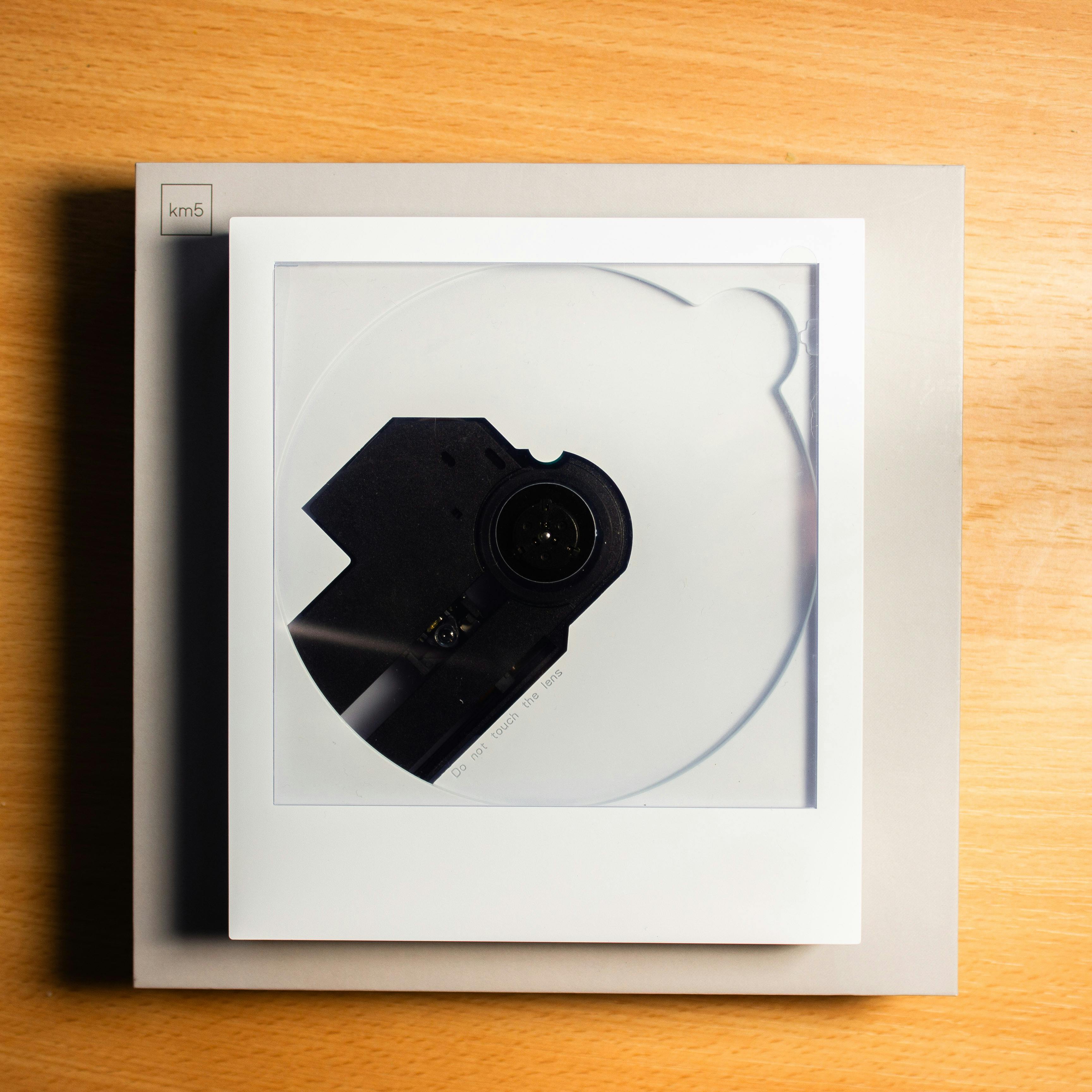 Δωρεάν Μια κάτοψη ενός σύγχρονου CD player με διαφανές καπάκι, τοποθετημένου σε ένα ξύλινο τραπέζι. Φωτογραφία από στοκ φωτογραφιών