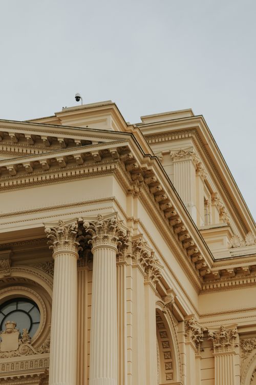 Free Close-up of a neoclassical building facade with ornate columns and intricate details. Stock Photo