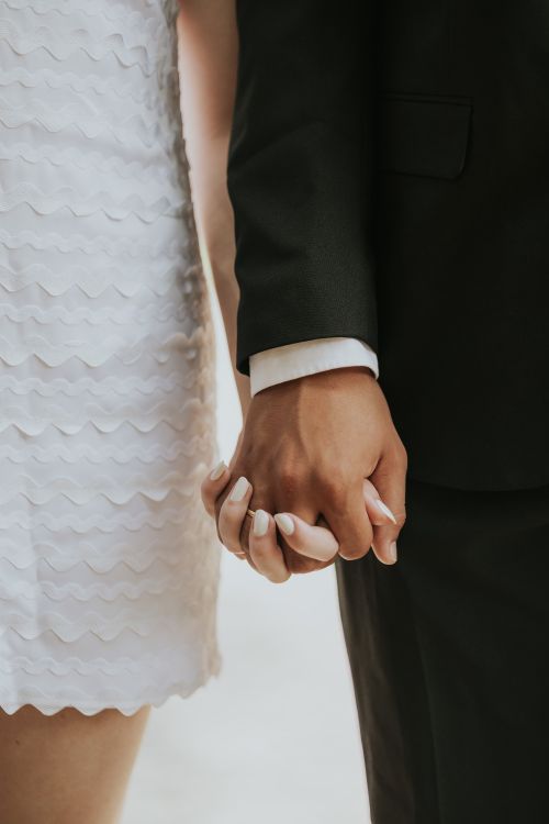Free Romantic close-up of a couple holding hands on their wedding day. Stock Photo