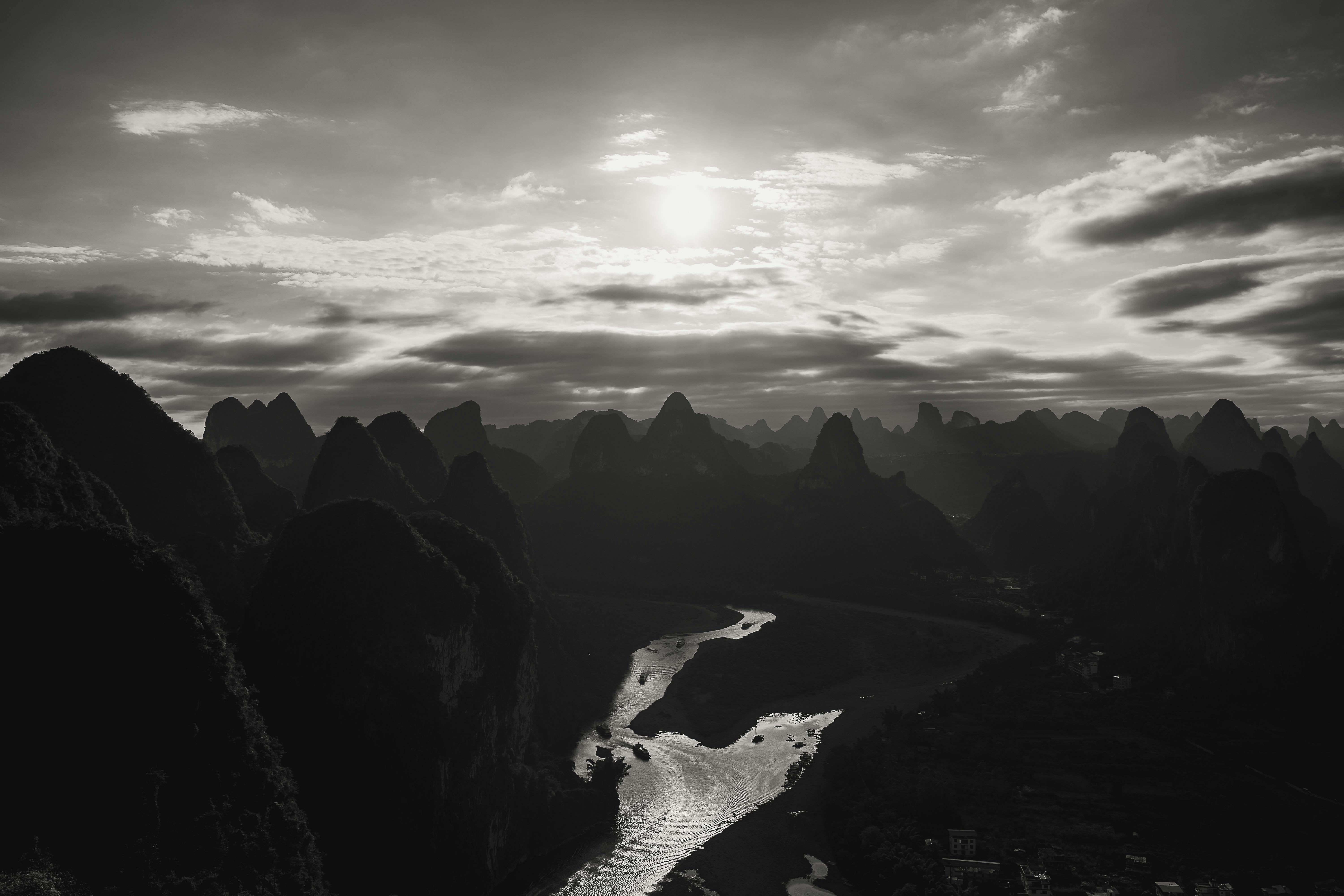 gratis Een adembenemend zwart-wit uitzicht op de Li-rivier die zich bij zonsondergang door het karstgebergte van Guilin slingert. Stockfoto