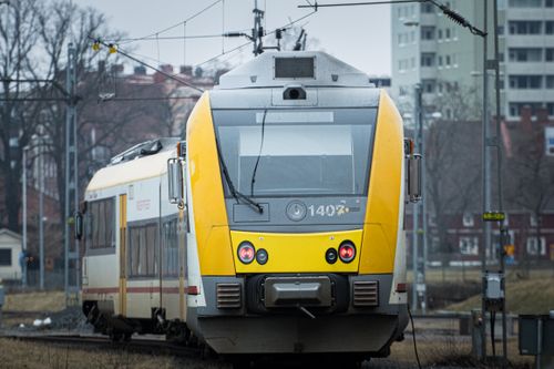 Free A modern passenger train approaches a station in Jonkoping, Sweden on a cloudy day. Stock Photo