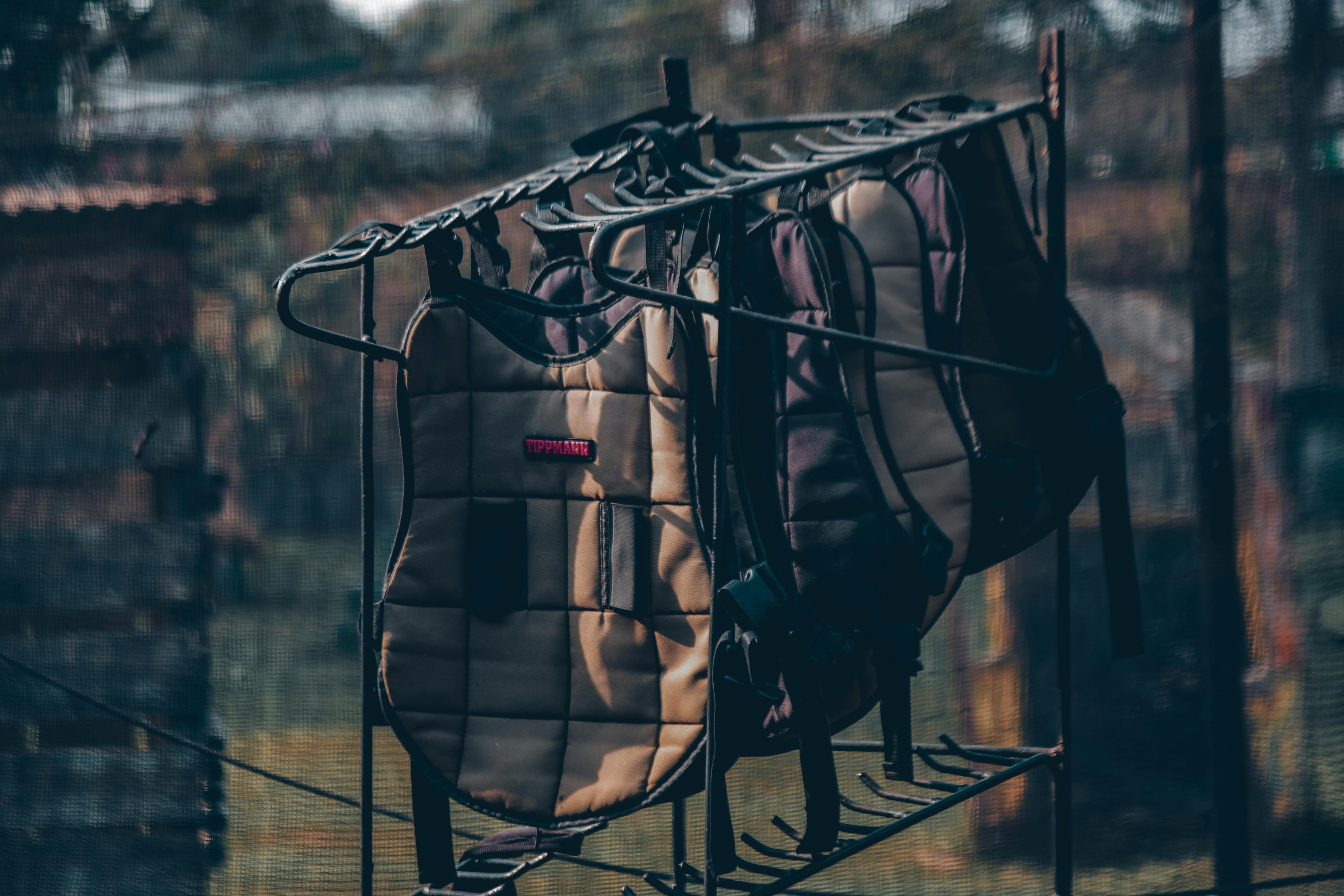 Gratis Equipo de protección para paintball colgado en un estante al aire libre, con la iluminación tenue de la tarde. Foto de stock