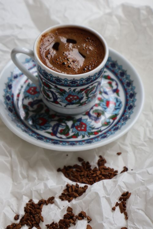 Free Artistic still life of a cup of Turkish coffee with scattered grounds. Stock Photo