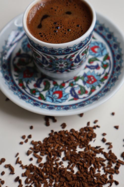 Free A close-up of Turkish coffee in a decorative floral cup with scattered grounds. Stock Photo