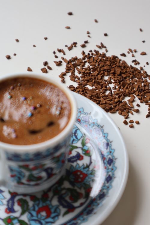 Free Close-up of Turkish coffee in a floral cup with spilled instant coffee granules. Stock Photo